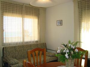 - un salon avec un canapé et une table fleurie dans l'établissement Alpen1 Paraiso, à Peñíscola
