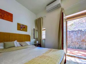 a bedroom with a large bed and a window at Villa Velta Calagrande in Porto Santo Stefano