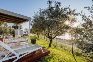 a patio with a table and chairs in a yard at Mobile Homes Sunset Beach in Umag
