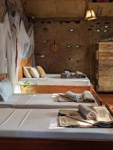 two beds in a room with two tables with towels at Backyard Eco Bungalows Moshi in Moshi +168 photos