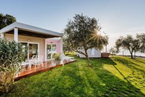 a small house with a deck and a yard at Mobile Homes Sunset Beach in Umag