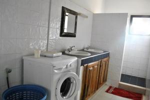 a bathroom with a washing machine and a sink at Appartement à Natangue 1 in Saly Portudal