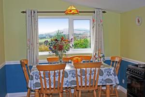 a dining room with a table and chairs and a window at 3 Bed in Sneem oc-i426 in Tullakeel