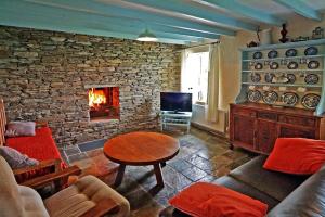 a living room with a stone wall with a fireplace at 3 Bed in Portmagee oc-i172 in Valentia Island