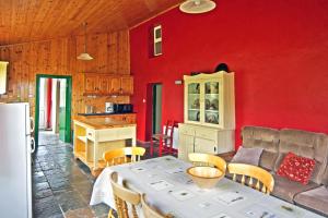 a kitchen with a red wall and a table and chairs at 3 Bed in Portmagee oc-i172 in Valentia Island