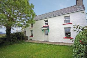 a white house with red windows and a yard at 3 Bed in Portmagee oc-i172 in Valentia Island