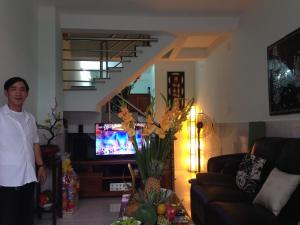 a man standing in a living room with a tv at homestay Huynh DC in Ho Chi Minh City