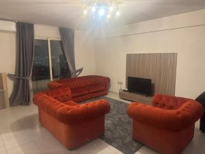a living room with two couches and a flat screen tv at SkyView Hotel & Apartments in Tirana +23 photos