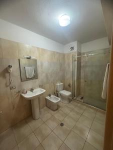 a bathroom with a sink and a toilet and a shower at SkyView Hotel & Apartments in Tirana