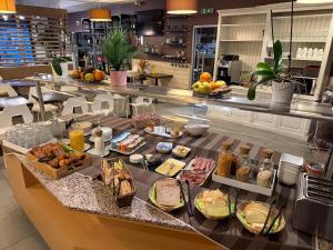 a buffet with many different types of food on a counter at Cit'Hotel Logis Le Chêne Vert in Les Sables-d'Olonne