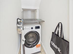 a washing machine in a laundry room with a bag at Southbourne beach in Southbourne +4 photos