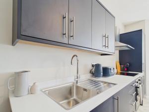 a kitchen with a sink and white cabinets at Southbourne beach in Southbourne