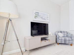 a living room with a television and a chair at Southbourne beach in Southbourne