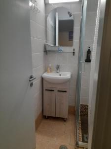 a small bathroom with a sink and a shower at Studios Eftichia in Fournoi +16 photos