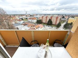 a bottle of wine on a table with a view of a city at Sky View Apartmán 10 patro in Břeclav
