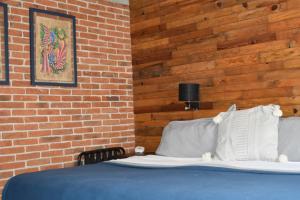 a bed in a room with a brick wall at CASAS FREDA - Centro Historico Departamentos in San Luis Potosí