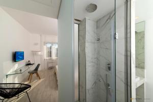 bagno con doccia in vetro e sedia di B&B San Pietro a Ischia