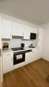 a kitchen with white cabinets and a stove top oven at Aurora Apartment in Vienna