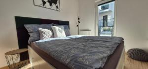 a bedroom with a bed and a window at Izzy Apartament in Myślenice