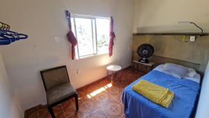 a bedroom with a bed and a chair and a window at Carioca Lapa Hostel in Rio de Janeiro