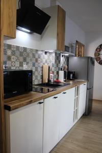 a kitchen with white cabinets and a stainless steel refrigerator at Izzy Apartament in Myślenice