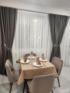 a dining room with a table and chairs and curtains at Podium Boutique Hotel in Yerevan