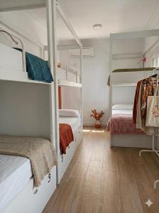 a room with two bunk beds and a wooden floor at Vivian's Guest House Auto Check-in in Jerez de la Frontera