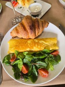 a white plate with a sandwich and a salad at Podium Boutique Hotel in Yerevan +30 photos