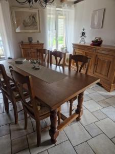 a dining room with a wooden table and chairs at Chez Bya in Bouvellemont
