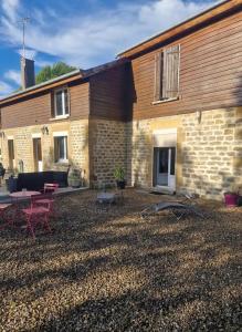 a brick building with a patio and a table at Chez Bya in Bouvellemont