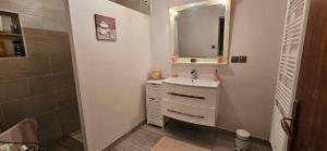 a white bathroom with a sink and a mirror at Chez Bya in Bouvellemont