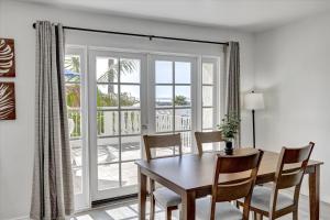 a dining room with a table and chairs and a window at Oceanside Marina Suites - A Waterfront Hotel in Oceanside