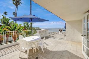 a patio with a table and chairs and an umbrella at Oceanside Marina Suites - A Waterfront Hotel in Oceanside