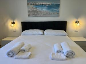 a white bed with towels on top of it at BaseFCO - Vicino Aeroporto e Mare in Isola Sacra