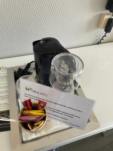 a piece of paper on a shelf with a coffee maker at Cit'Hotel Logis Le Chêne Vert in Les Sables-d'Olonne