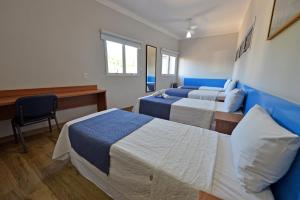 a hotel room with two beds and a desk at Vinds Economic Hotel in Ipatinga +60 photos