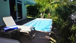 a chair sitting next to a swimming pool at Moorea - Temae Reef Cottage in Temae