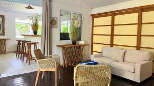a living room with a couch and chairs at Moorea - Temae Reef Cottage in Temae