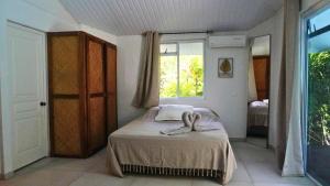 a bedroom with a bed with towels on it at Moorea - Temae Reef Cottage in Temae +20 photos