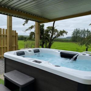 a hot tub sitting under a pergola at The Truck with private hot tub -Garvagh retreats in Ballynameen