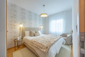 a bedroom with a large white bed and a couch at Cozy Haven Santana - Nature & Hiking Trails in Santana