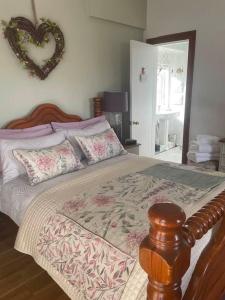 a bedroom with a bed with a heart on the wall at Waters Edge Cottage in Alexandria