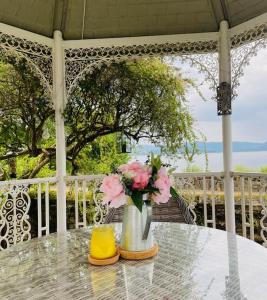 a glass table with a vase of flowers on a porch at Waters Edge Cottage in Alexandria