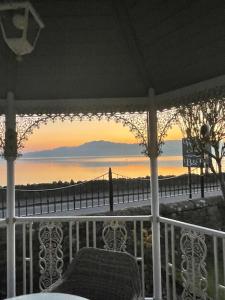 a porch with a chair and a view of the water at Waters Edge Cottage in Alexandria