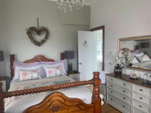 a bedroom with a bed and a mirror and a dresser at Waters Edge Cottage in Alexandria