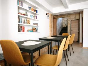 a dining room with black tables and yellow chairs at Vila Olivín - Private rooms with bathroom in Banská Bystrica