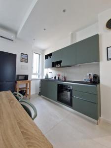 a large kitchen with green cabinets and a table at House 13 apartment in Cernobbio in Cernobbio