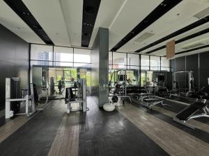 a gym with treadmills and machines in a room at Perfectly Located Airport Link Train City Access in Bangkok