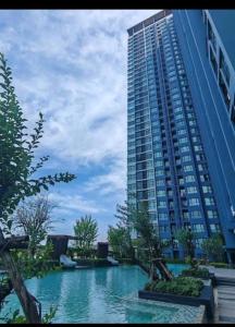 a large building with a pool of water in front of it at Perfectly Located Airport Link Train City Access in Bangkok