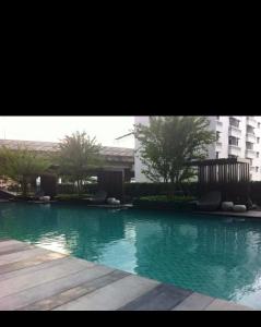 a large pool of water in front of a building at Perfectly Located Airport Link Train City Access in Bangkok